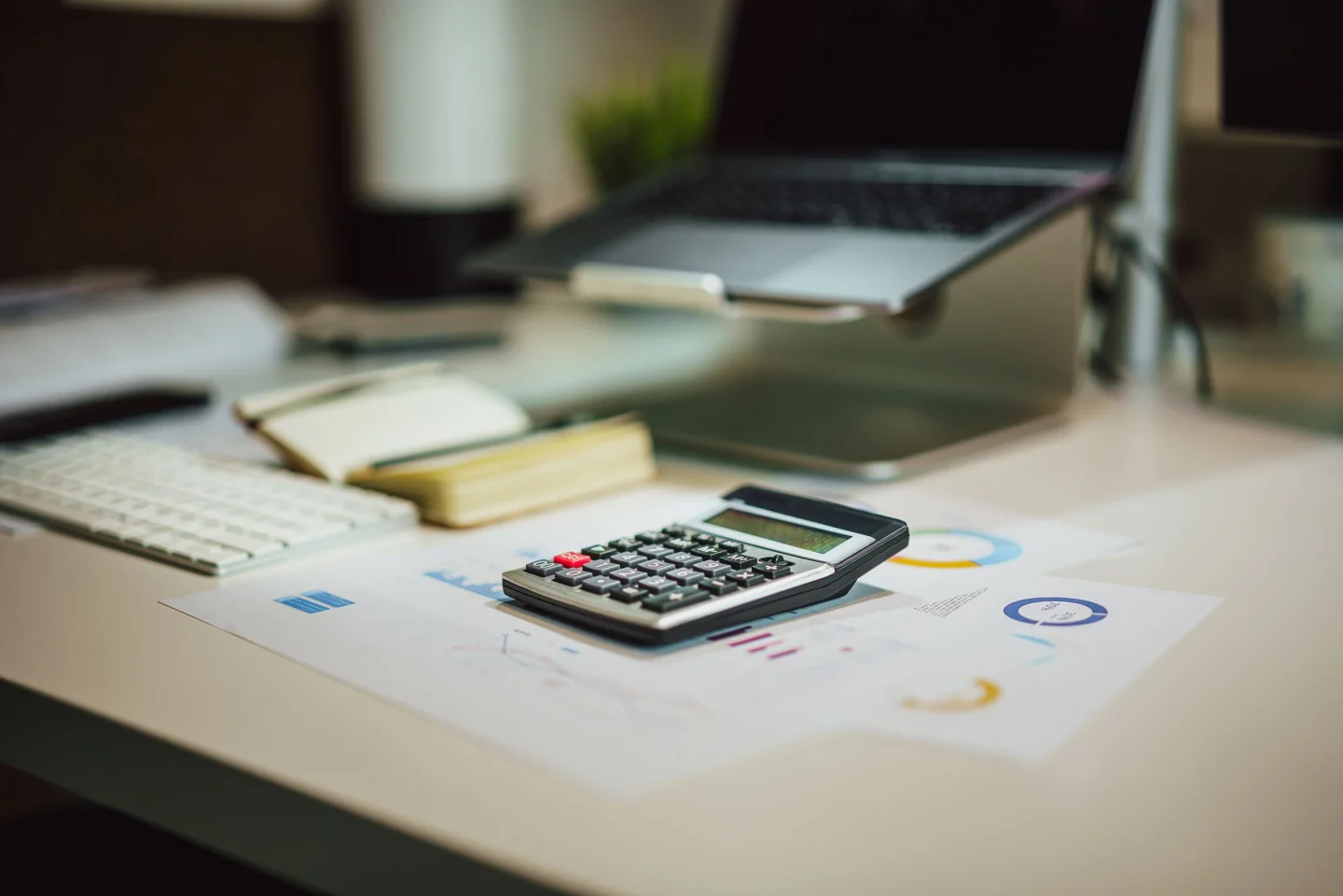 A desk with a laptop, calculator and paperwork (illustrative)